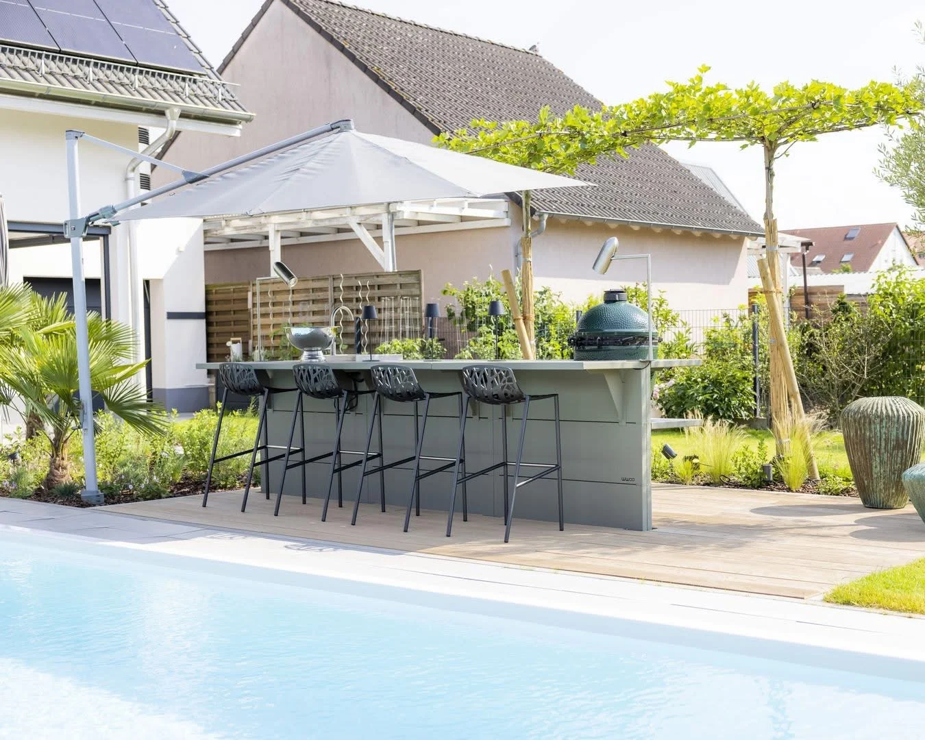 Steel kitchen island next to a pool.